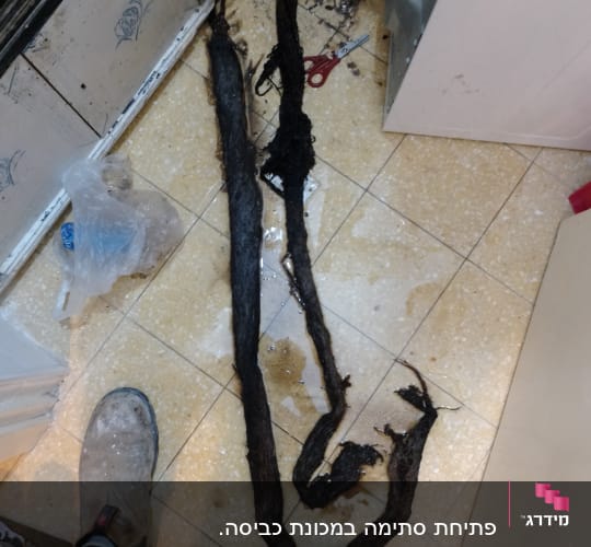 חפץ שחור ארוך על רצפה ליד נעליים